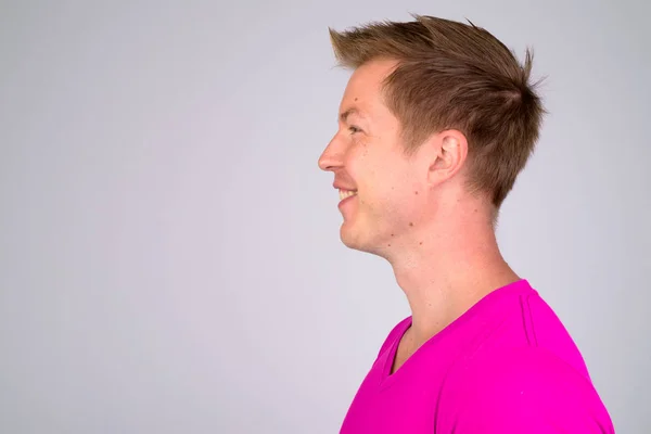 Profilo vista di felice giovane bell'uomo sorridente e indossa camicia viola — Foto Stock