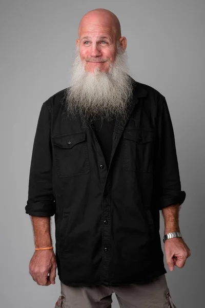 Studio colpo di felice maturo pelato barbuto uomo sorridente mentre pensa — Foto Stock