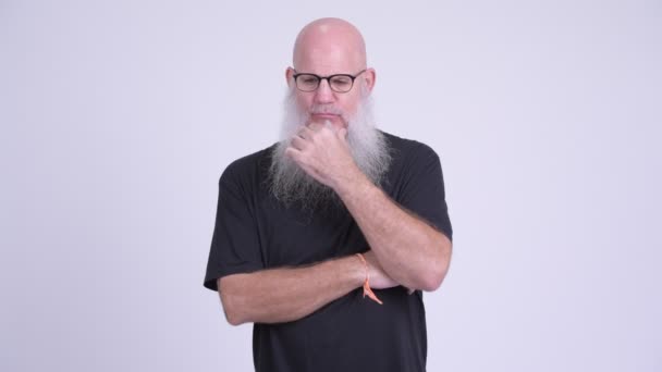 Mature bald bearded man looking serious while thinking — Stock Video