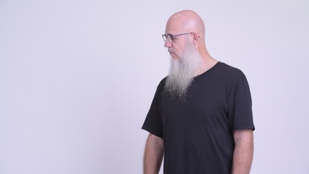 Счастливый взрослый лысый бородатый мужчина улыбается, показывая что-то — стоковое видео