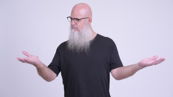 Mature bald bearded man comparing something — Stock Video