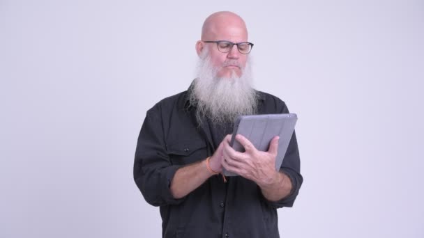Pria berjenggot botak dewasa yang tertekan menggunakan tablet digital dan mendapatkan berita buruk — Stok Video