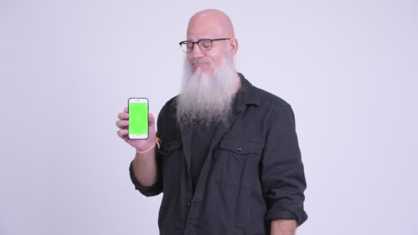 Feliz maduro careca barbudo homem mostrando telefone e dando polegares para cima — Vídeo de Stock