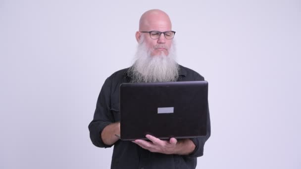 Happy mature bald bearded man using laptop — Stock Video