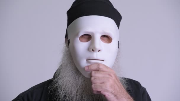 Зрелый бородатый хипстер раскрывает лицо за белой маской — стоковое видео