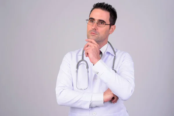 Retrato de homem bonito médico pensando contra fundo branco — Fotografia de Stock