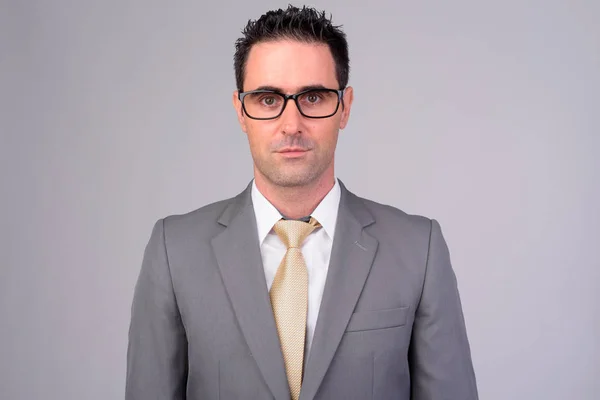 Pohledný podnikatel v obleku nosit brýle proti bílým pozadím — Stock fotografie