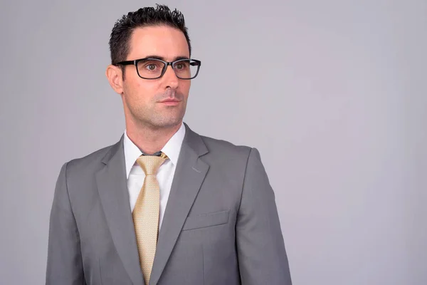 Stilig affärsman i kostym tänkande med glasögon mot vit bakgrund — Stockfoto
