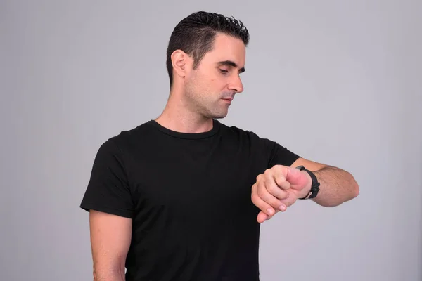 Portrait de bel homme vérifiant le temps sur fond blanc — Photo