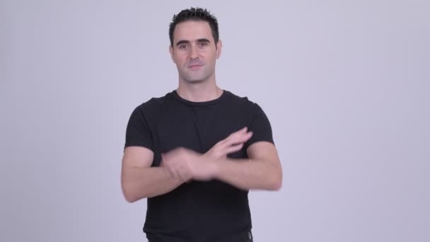 Gelukkig knap man die lacht met armen gekruist tegen witte achtergrond — Stockvideo