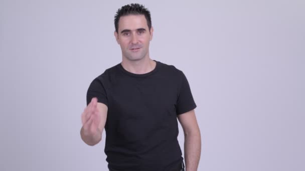 Ευτυχισμένος όμορφος άνθρωπος δίνει χειραψία ενάντια σε λευκό φόντο — Αρχείο Βίντεο