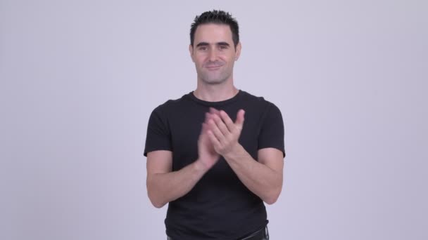 Glücklich schöner Mann klatscht Hände vor weißem Hintergrund — Stockvideo