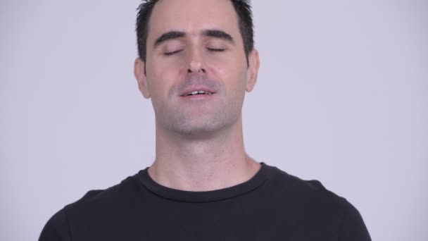 Face of handsome man relaxing with eyes closed against white background — Stock Video