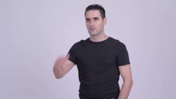 Handsome man searching for something against white background — Stock Video