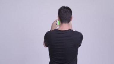 Arkadan Görünüş adamın telefonu beyaz arka plan ile fotoğraf çekimi