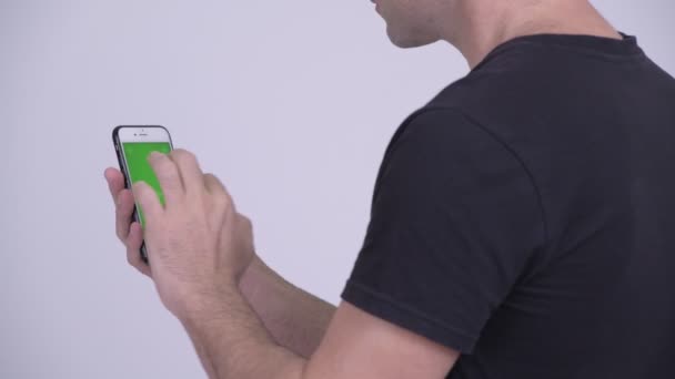 Vue arrière de l'homme utilisant le téléphone sur fond blanc — Video