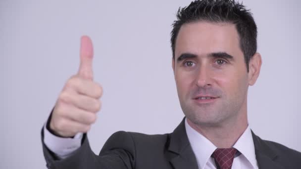 Gesicht eines glücklichen gutaussehenden Geschäftsmannes, der beim Daumendrücken denkt — Stockvideo