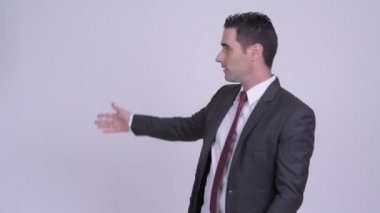 Yakışıklı işadamı beyaz arka plan karşı bir şey sunmak