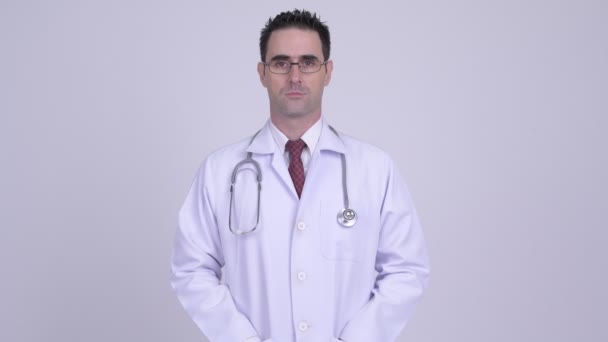 Счастливый красивый мужчина врач улыбается на белом фоне — стоковое видео