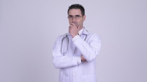 Knappe man arts denken terwijl het dragen van bril tegen witte achtergrond — Stockvideo