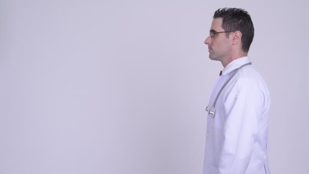 Vista de perfil del guapo doctor hombre con anteojos sobre fondo blanco — Vídeos de Stock