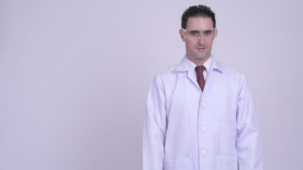 Lycklig stilig man läkare med skyddande glasögon visar något — Stockvideo
