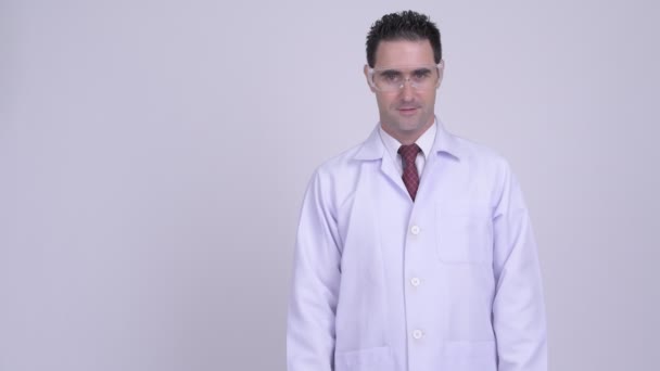 Feliz hombre guapo doctor con gafas protectoras apuntando hacia arriba — Vídeos de Stock