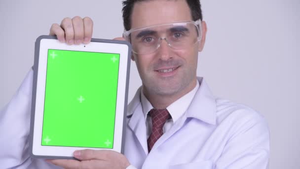 Glücklicher schöner Mann Arzt mit Schutzbrille zeigt digitales Tablet — Stockvideo