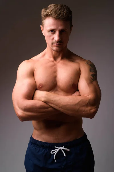 Muskulöser gutaussehender bärtiger Mann ohne Hemd mit verschränkten Armen — Stockfoto