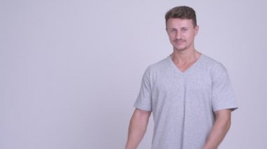 Mutlu yakışıklı sakallı adam bir şeyler gösteriyor