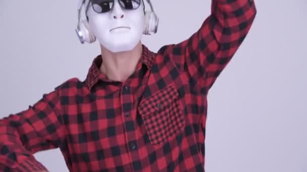 Maskerade hipster man bär solglasögon och hörlurar som Dj — Stockvideo