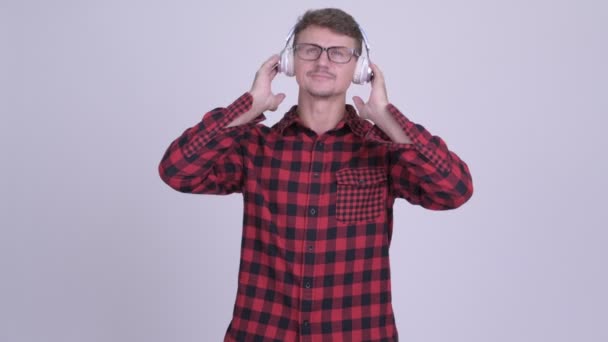 Knappe bebaarde hipster man muziek beluisteren — Stockvideo