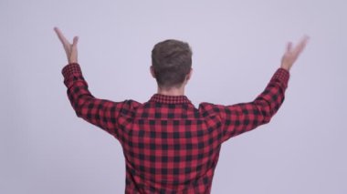 Arkadan Görünüş mutlu hipster adam kollarını kaldırdı tezahürat