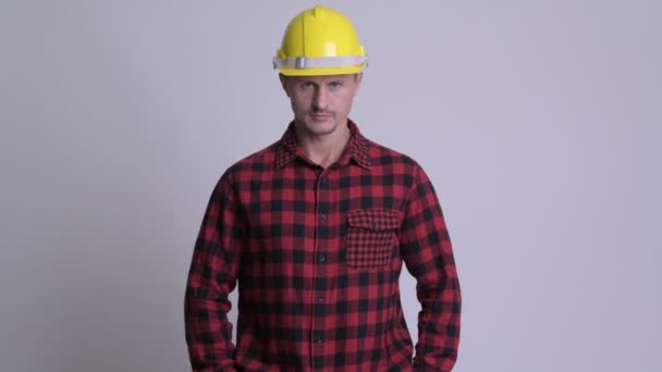 Красивий бородатий чоловік будівельник на білому тлі — стокове відео