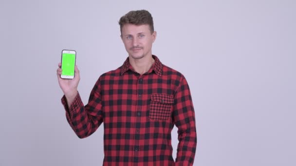 Gelukkig bebaarde hipster man geven duimen omhoog terwijl weergegeven: telefoon — Stockvideo