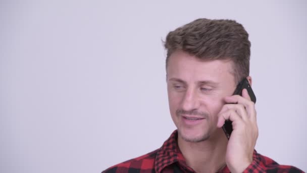 Обличчя щасливого бородатого хіпстера, який розмовляє по телефону — стокове відео