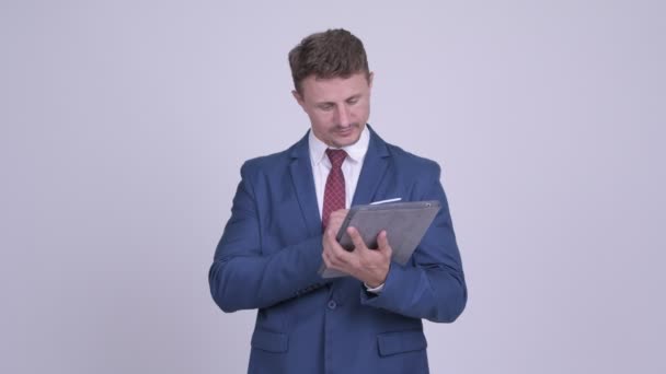 Feliz hombre de negocios barbudo pensando mientras usa la tableta digital — Vídeo de stock