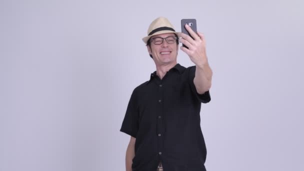 Mature handsome tourist man taking selfie and video calling — Stock Video