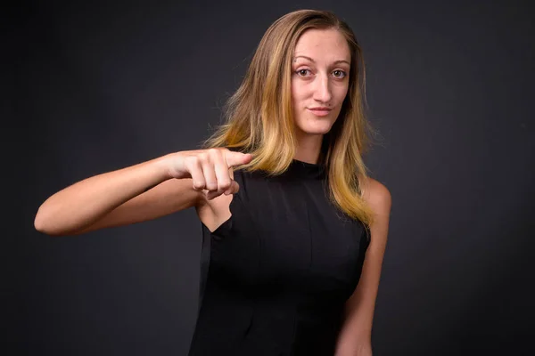 Junge schöne Geschäftsfrau mit glatten blonden Haaren gegen g — Stockfoto