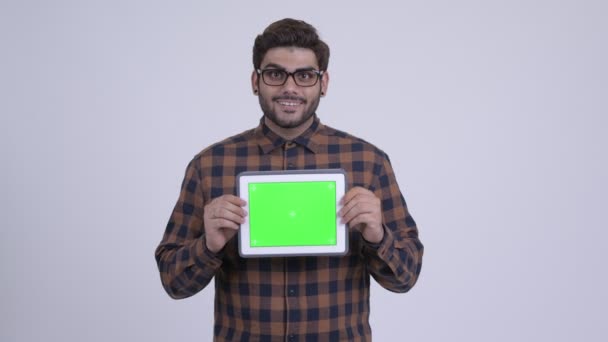 Счастливый молодой бородатый индийский хипстер показывает цифровой планшет — стоковое видео