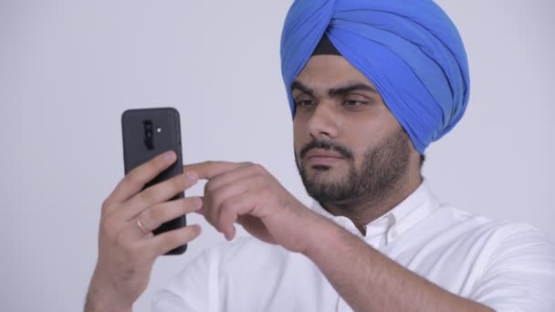 Ansikte av unga skäggig indisk sikhiska man använder telefon — Stockvideo