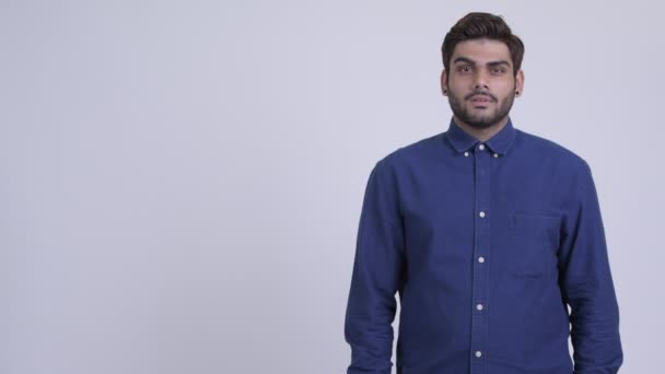 Щасливі молодих бородатий індійський бізнесмен, думаючи і угору — стокове відео