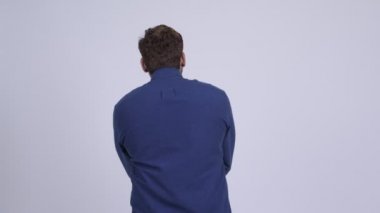 Genç Hintli iş adamının arka görüntüsü bekliyor ve düşünüyor.