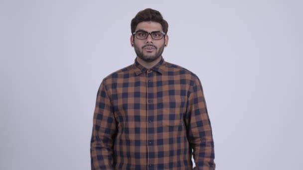 Young bearded Indian hipster man covering mouth and looking guilty — Stock Video
