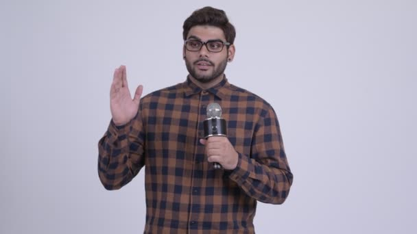 Ung skäggig indisk hipster man förklara något med mikrofon — Stockvideo