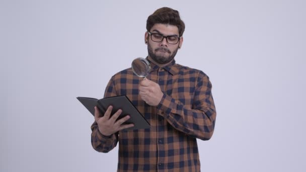 Heureux jeune homme barbu indien hipster livre de lecture avec loupe — Video