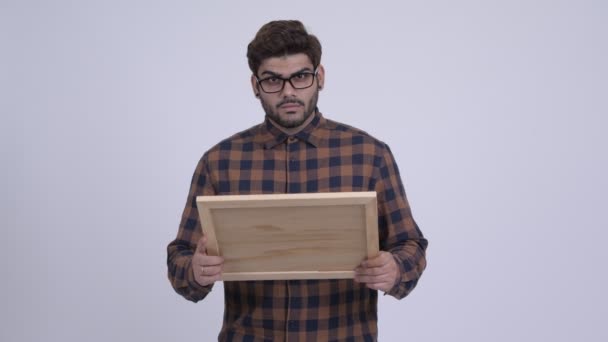 Glad ung skäggig indisk hipster mannen hålla blackboard och ger tummen upp — Stockvideo