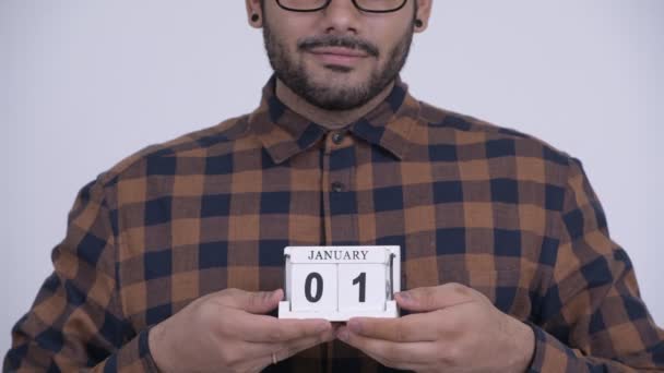 Ευτυχισμένος νέος γενειοφόρο άτομο ινδική hipster κρατώντας ημερολόγιο μπλοκ έτοιμη για το νέο έτος — Αρχείο Βίντεο