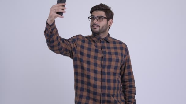 Happy young bearded Indian hipster man taking selfie with phone — Stock Video