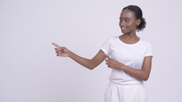 Feliz joven hermosa mujer africana señalando y mostrando algo — Vídeos de Stock